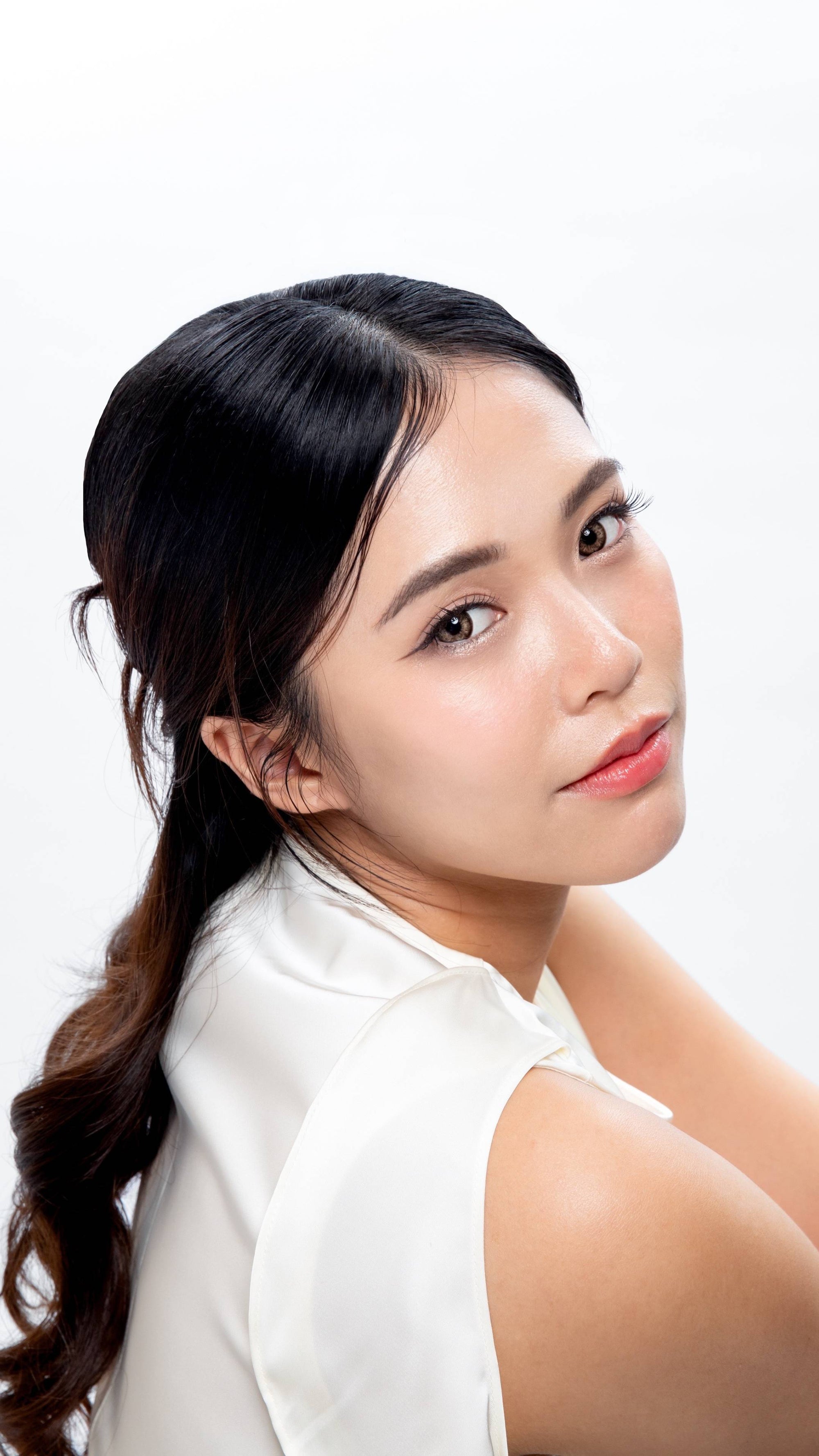 Close-up of a model with fair to medium skin, wearing joocy natural glow cosmetic lenses in Exclusive, showing seamless blending on dark eyes