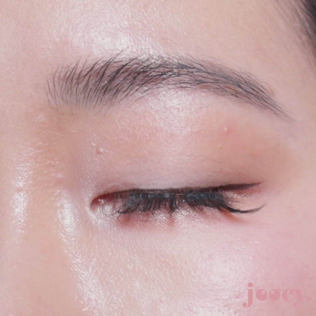 A macro close-up video of a single eye blinking on a fair-skinned model to show the joocy olive-brown lens in shade Jelita. The quiet-luxury ochre-hazel pattern blends naturally on dark irises and universally flatters deep skin tones too.